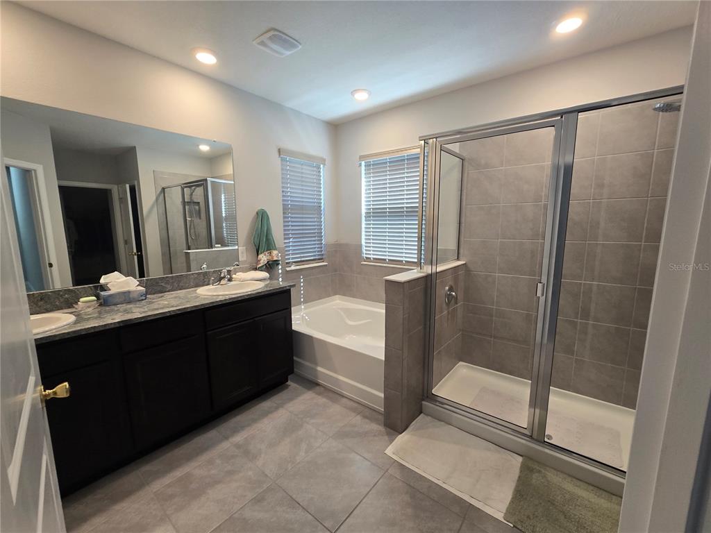 5846 Southwest 80th Lane Ocala, FL 34476 - Photo 25 of 27 a bathroom with a double vanity sink a toilet mirror and shower