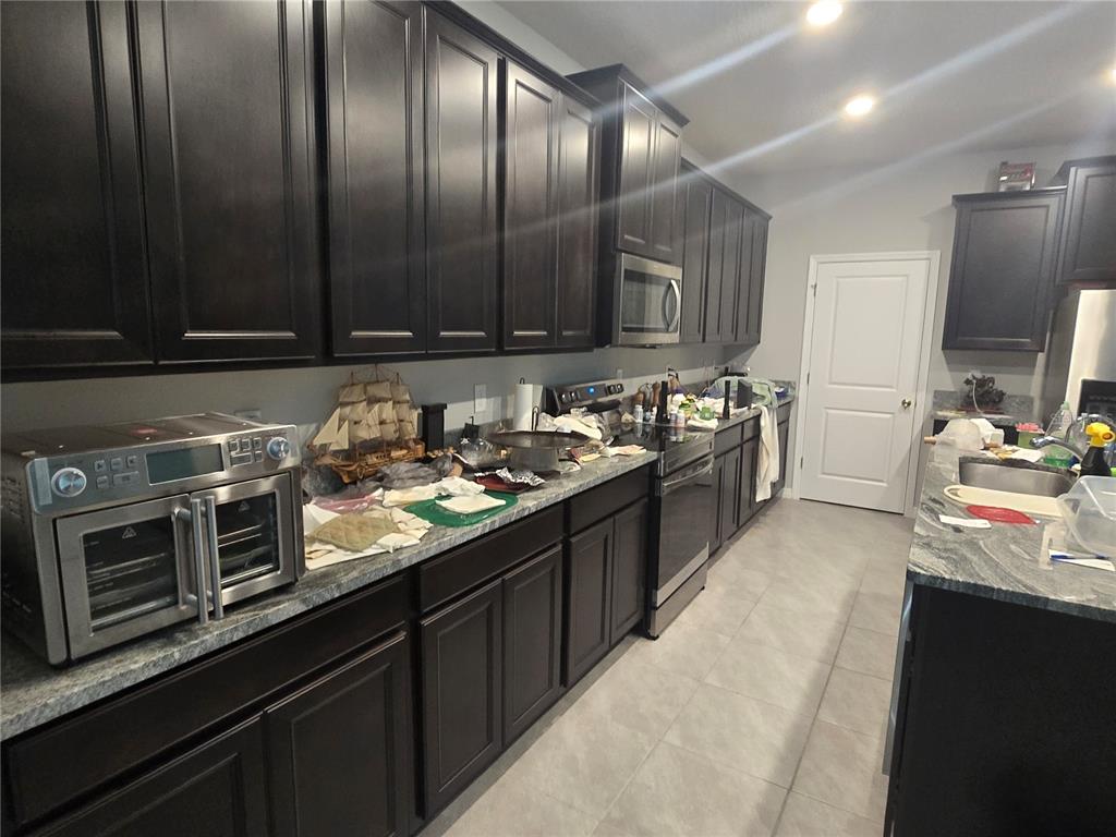 5846 Southwest 80th Lane Ocala, FL 34476 - Photo 9 of 27 a kitchen with stainless steel appliances granite countertop a sink stove and cabinets