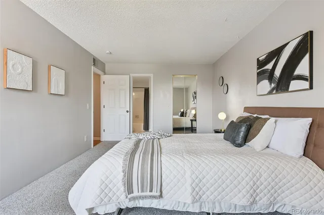 a bedroom with a bed and painting on the wall