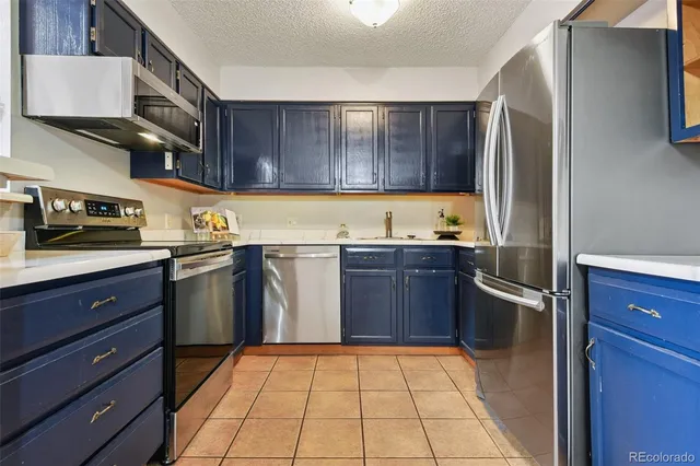 a kitchen with a refrigerator sink and cabinets
