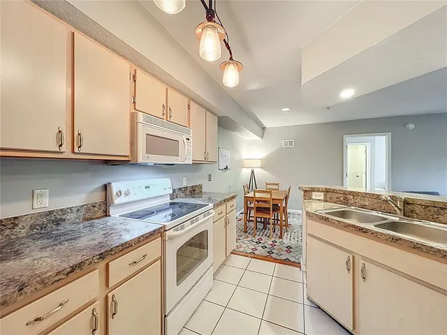 a kitchen with granite countertop white cabinets and white appliances