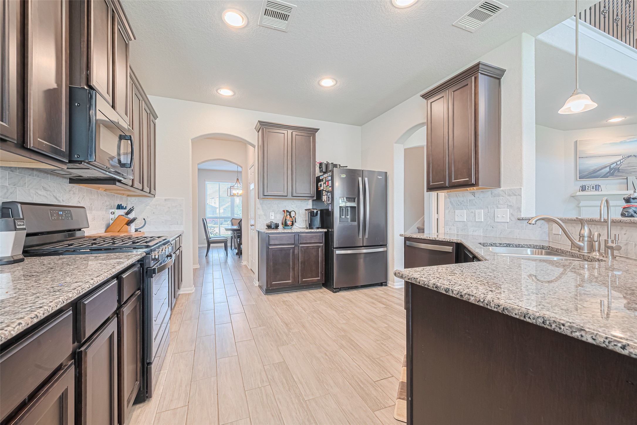 4507 Shallow Hill Court Houston, TX 77084 - Photo 13 of 50 a kitchen with refrigerator a sink and wooden cabinets