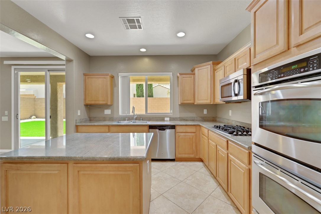 2501 Bechamel Place Henderson, NV 89044 - Photo 9 of 50 Culinary aspirations find their home in this well-appointed kitchen featuring abundant counter space and modern appliances.
