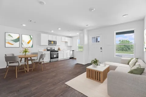 a living room with furniture wooden floor and kitchen view