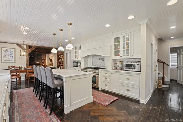 a kitchen with kitchen island a stove a table and chairs