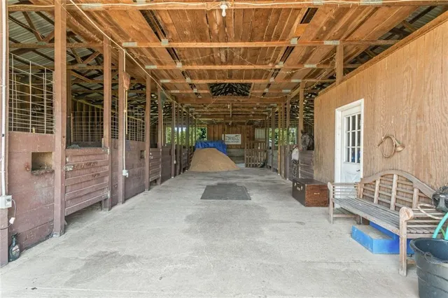 a view of pool with lawn chairs and large trees