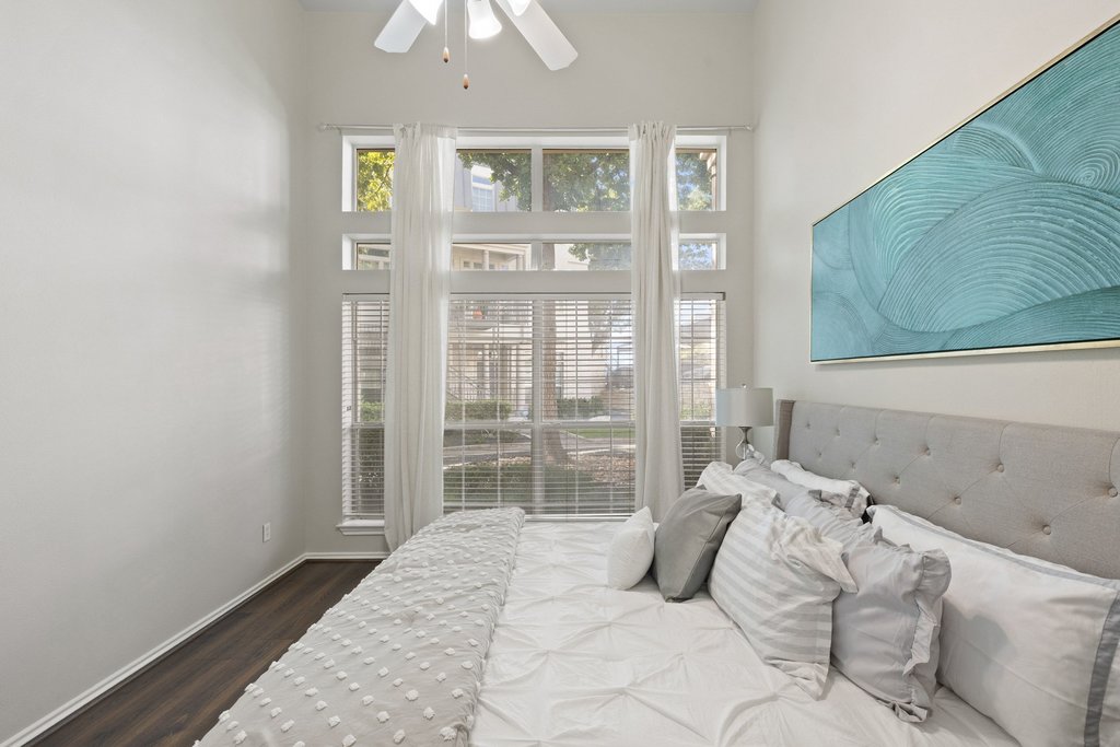 2918 Ranch Road 620 North, Unit 268 Austin, TX 78734 - Photo 22 of 40 Towering windows flood this airy primary bedroom with abundant natural light over wood flooring.