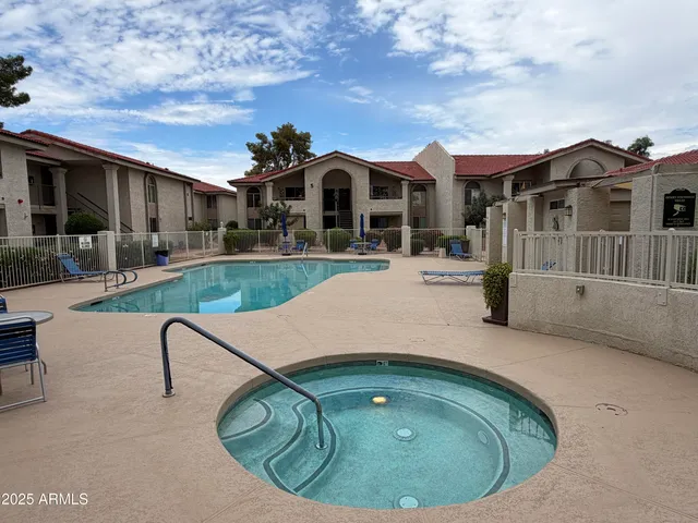 a view of a white house with a swimming pool and a yard