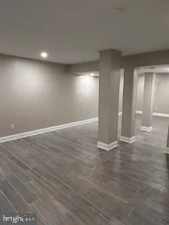 a view of an empty room with wooden floor