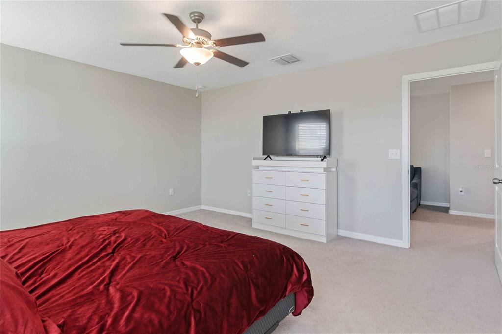 9440 Lemon Drop Loop Sun City Center, FL 33573 - Photo 33 of 55 a bedroom with a bed and a flat screen tv