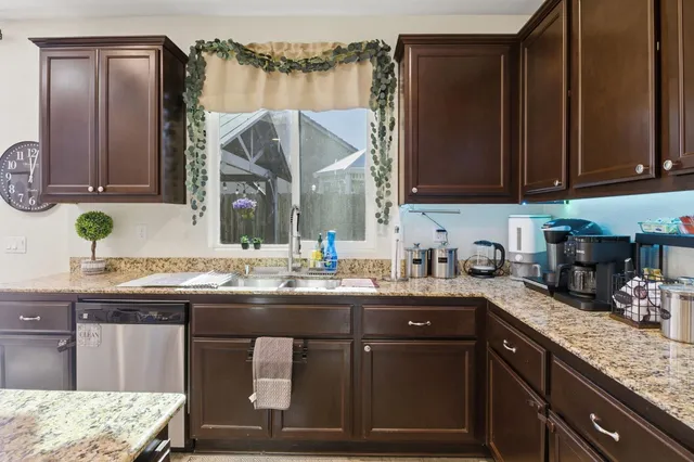a kitchen with kitchen island granite countertop a sink a stove and cabinets