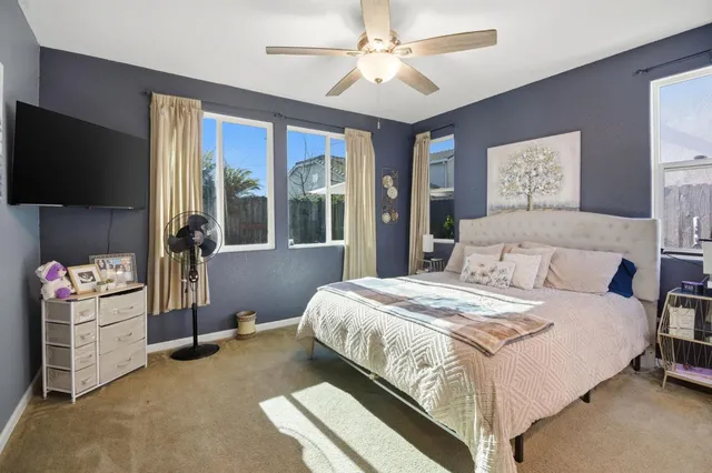 a bedroom with a bed and a flat tv screen on dresser