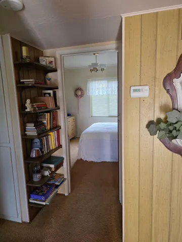 a bedroom with a bed and a book shelf