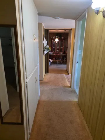 a view of a hallway and a livingroom with furniture
