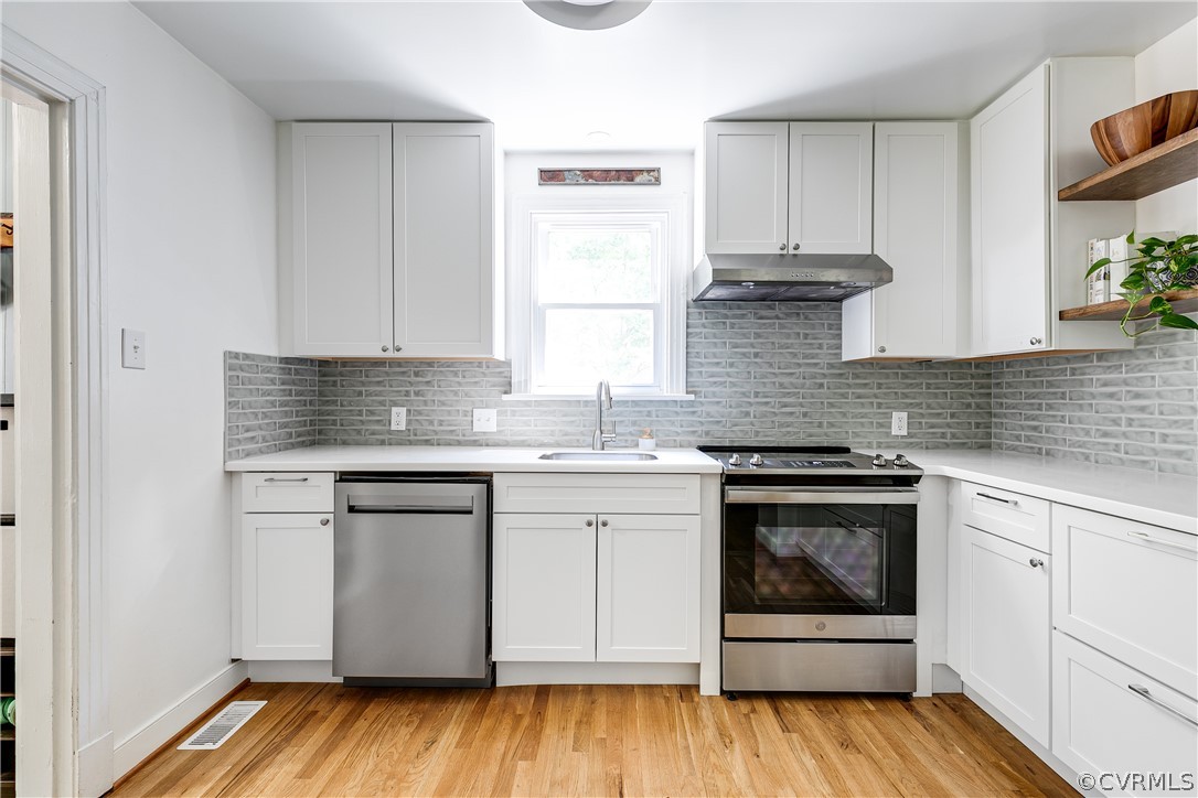 8934 Elm Road Richmond, VA 23235 - Photo 16 of 37 a kitchen with stainless steel appliances granite countertop a stove and white cabinets