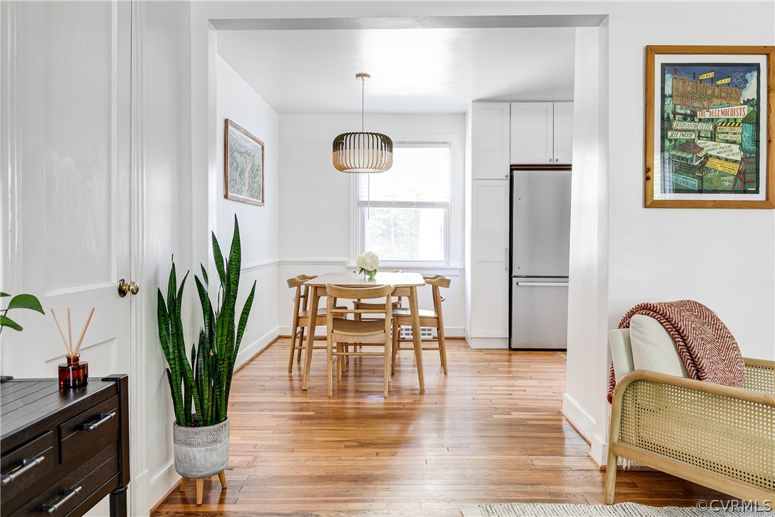 8934 Elm Road Richmond, VA 23235 - Photo 9 of 37 a dining room with furniture potted plants and wooden floor