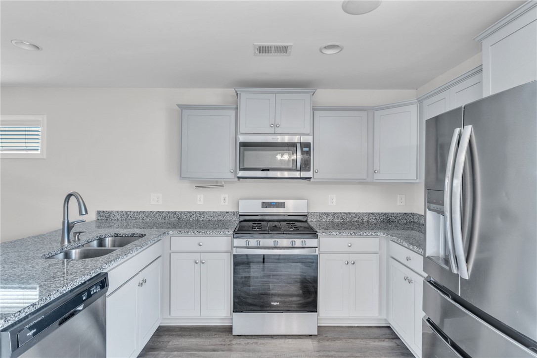 208 Samuel Street Pendleton, SC 29670 - Photo 8 of 32 A contemporary kitchen showcasing ample countertop space and a suite of stainless steel appliances.