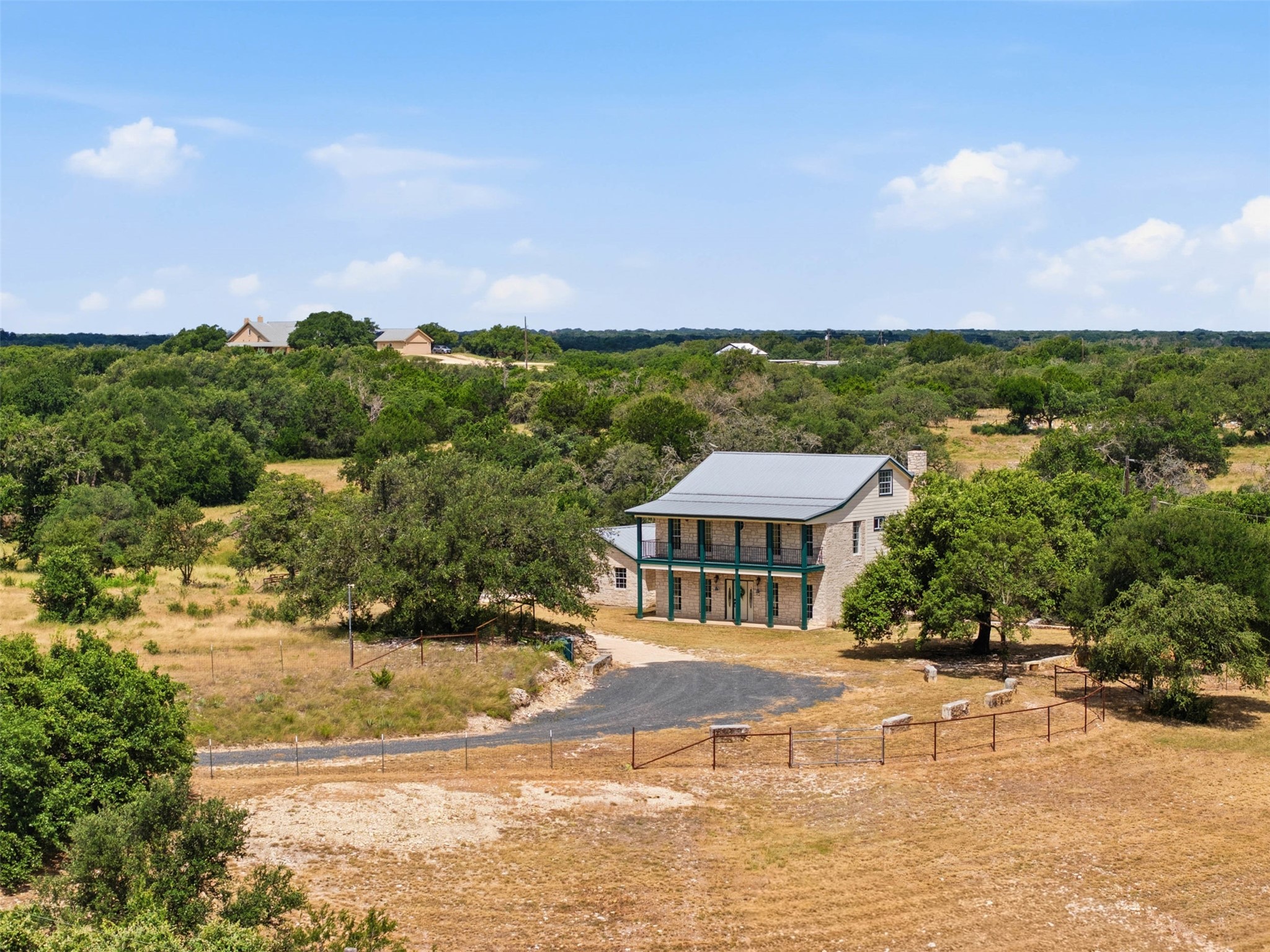 720 Spring Creek Road Florence, TX 76527 - Photo 3 of 40 Covered porches on both the front and back. The standing seam metal roof was installed in 2018. In 2025 the porch columns and balcony railings were replaced.