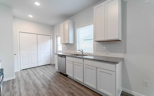 a kitchen with granite countertop white cabinets and white appliances