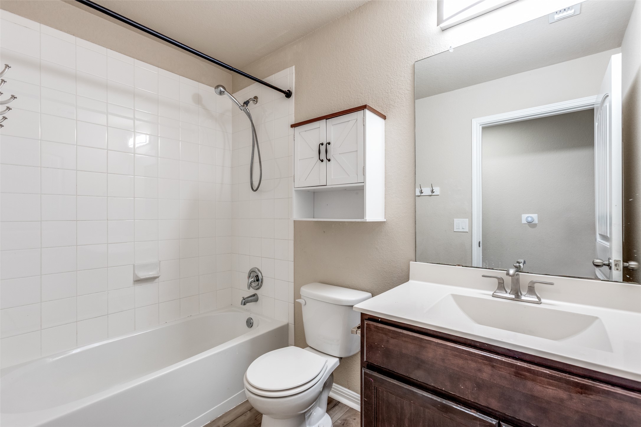 2909 Centrum Drive Austin, TX 78754 - Photo 26 of 30 This bathroom features a white bathtub with subway tile surround, a toilet, and a vanity with a white countertop and dark wood cabinetry