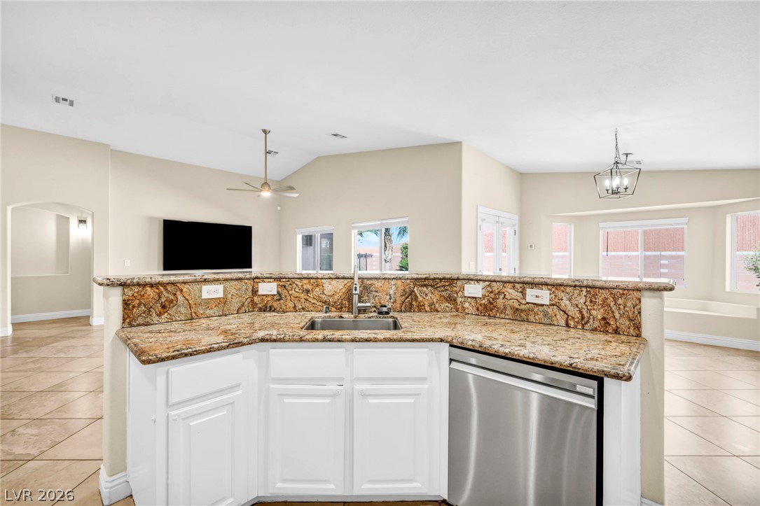 6405 North Raptor Court North Las Vegas, NV 89084 - Photo 6 of 66 A well-appointed kitchen island with a gleaming stainless steel sink and granite countertops anchors this inviting space.