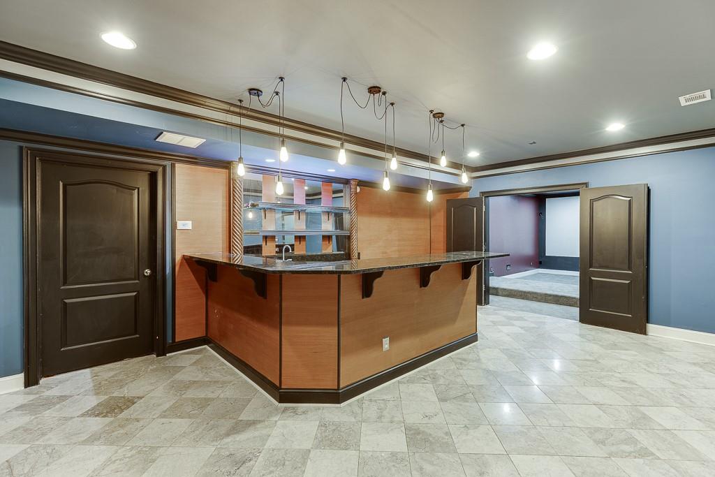940 Chateau Forest Road Hoschton, GA 30548 - Photo 56 of 87 a kitchen with stainless steel appliances kitchen island granite countertop a refrigerator and a sink