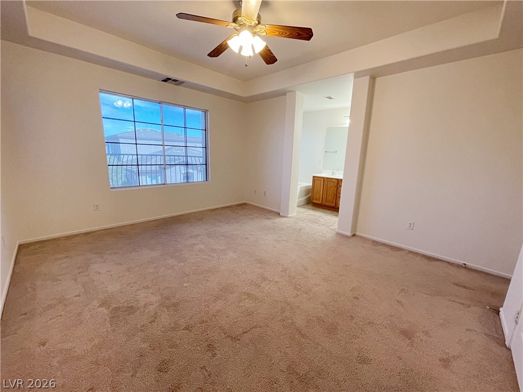 691 Principle Point Avenue Henderson, NV 89012 - Photo 20 of 30 A spacious bedroom offers a tranquil retreat with plush carpeting and an adjoining primary bath.