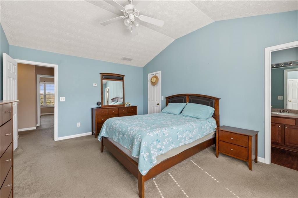 1558 Paramount View Trace Northeast Sugar Hill, GA 30518 - Photo 11 of 21 a bedroom with a bed and a chandelier