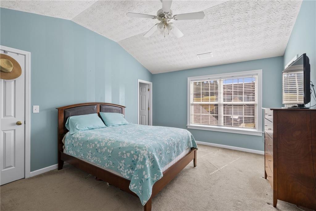 1558 Paramount View Trace Northeast Sugar Hill, GA 30518 - Photo 10 of 21 a bed sitting in a spacious bedroom next to a window