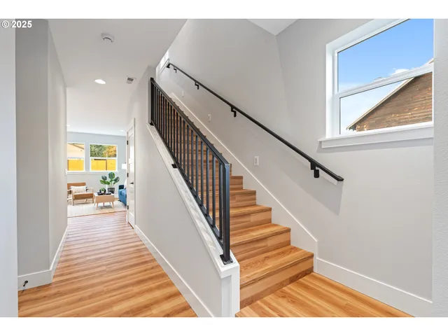 a view of entryway and hall with wooden floor