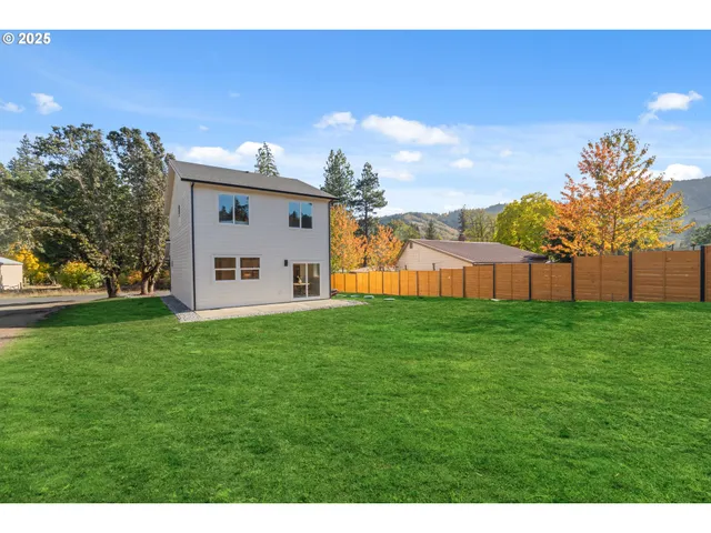 a view of a backyard with grass and a garage