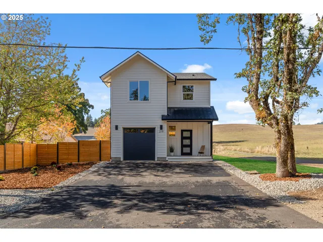 a view of a house with backyard and tree