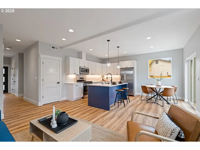 a living room with stainless steel appliances kitchen island granite countertop furniture and a dining table