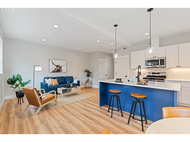 a living room with kitchen island furniture and a wooden floor