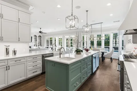 a large kitchen with kitchen island a sink a center island a counter space and a view of living room