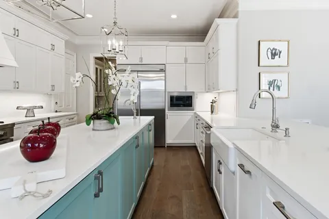 a kitchen with white cabinets and sink