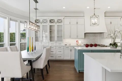 a kitchen with cabinets appliances and a dining table