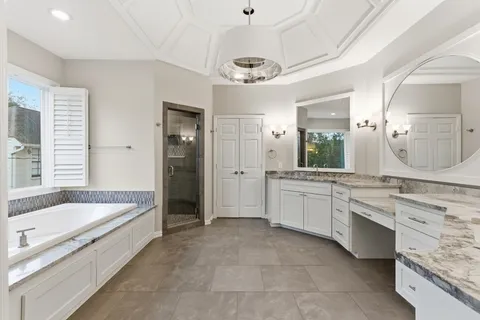 a large spacious bathroom with a granite countertop tub sink shower and mirror