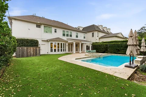a view of a house with a yard patio and swimming pool