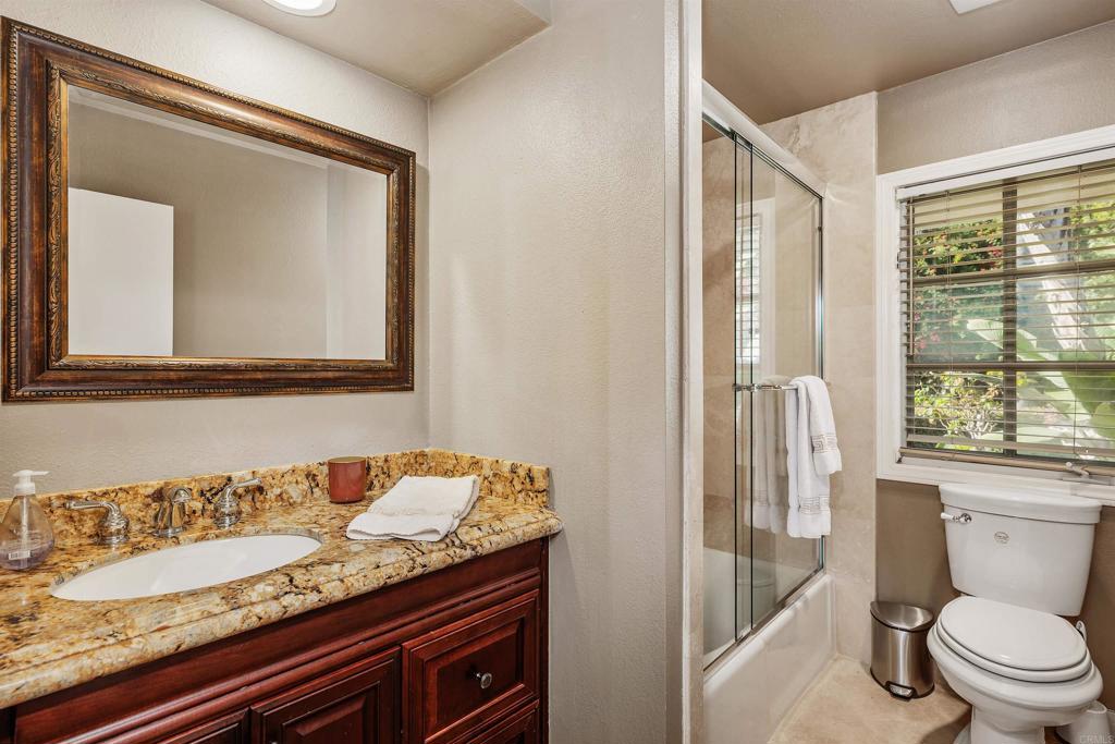 16346 Via Del Alba Rancho Santa Fe, CA 92067 - Photo 33 of 34 a bathroom with a granite countertop sink a toilet a mirror and a window