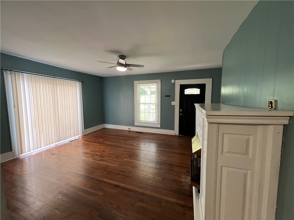 309 Jaynes Street Walhalla, SC 29691 - Photo 3 of 12 Refinished hardwood floors and a cozy fireplace create an inviting atmosphere in this sun-drenched living space.