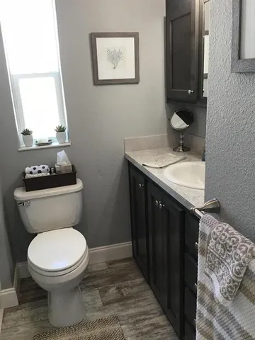 a bathroom with a granite countertop toilet and a mirror