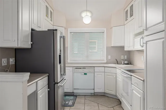 a kitchen with white cabinets and white appliances