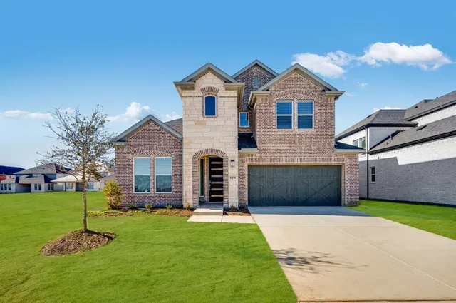 a front view of a house with a garden and yard