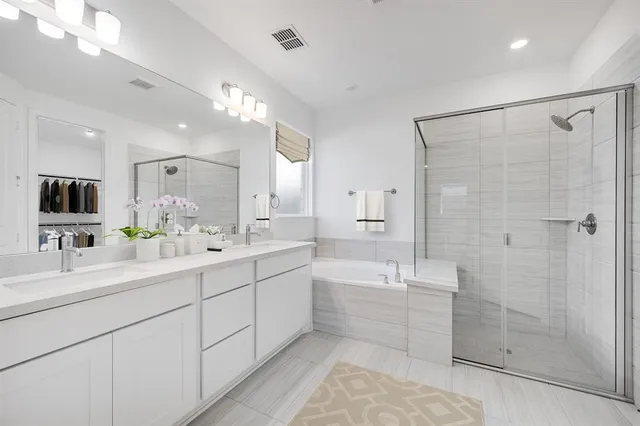 a bathroom with a double vanity sink mirror and shower