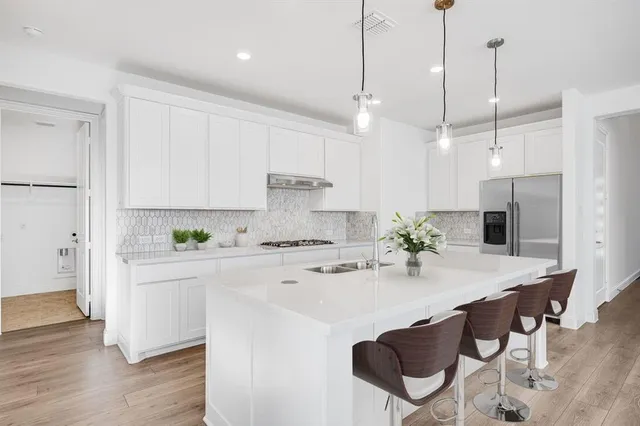a kitchen with kitchen island a stove a table and chairs in it