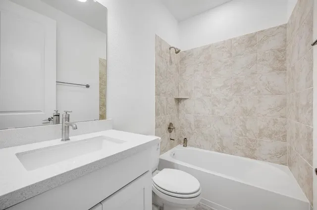 a bathroom with a sink mirror toilet and bathtub