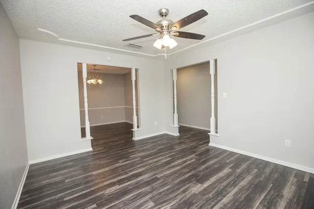 a view of an empty room with wooden floor