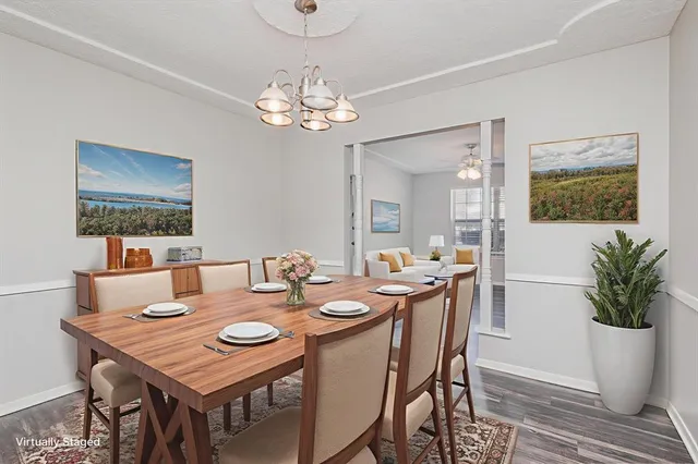 a view of a dining room with furniture a chandelier and wooden floor