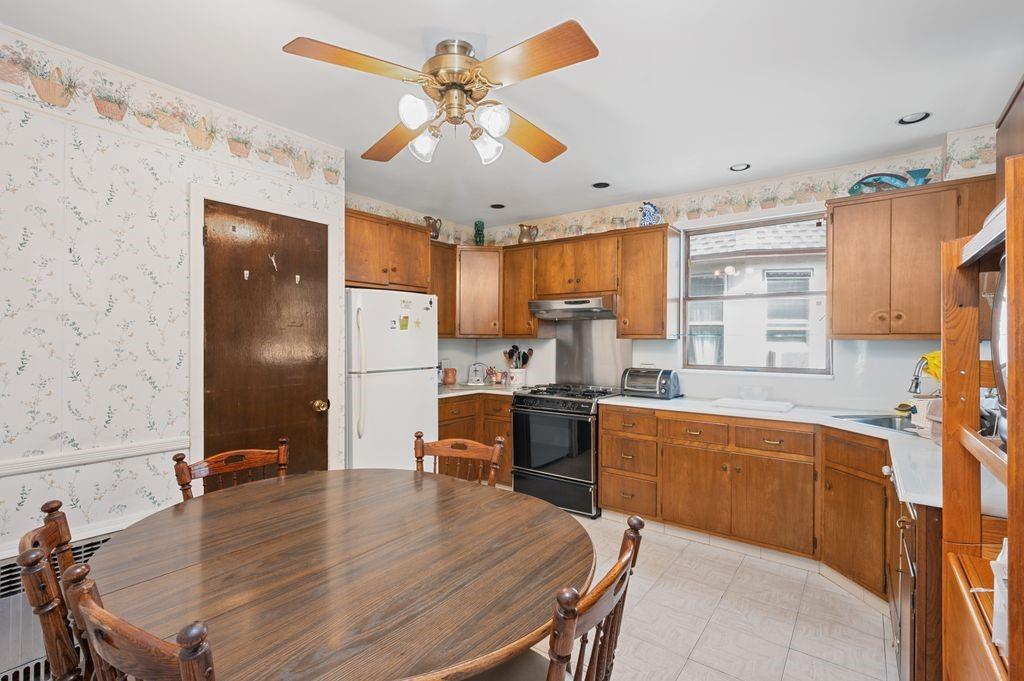 475 Argyle Road Brooklyn, NY 11218 - Photo 14 of 35 a kitchen with a table chairs refrigerator and cabinets